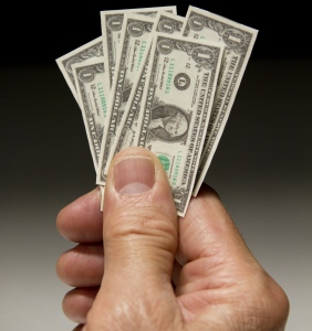 Man holding tiny dollar bills